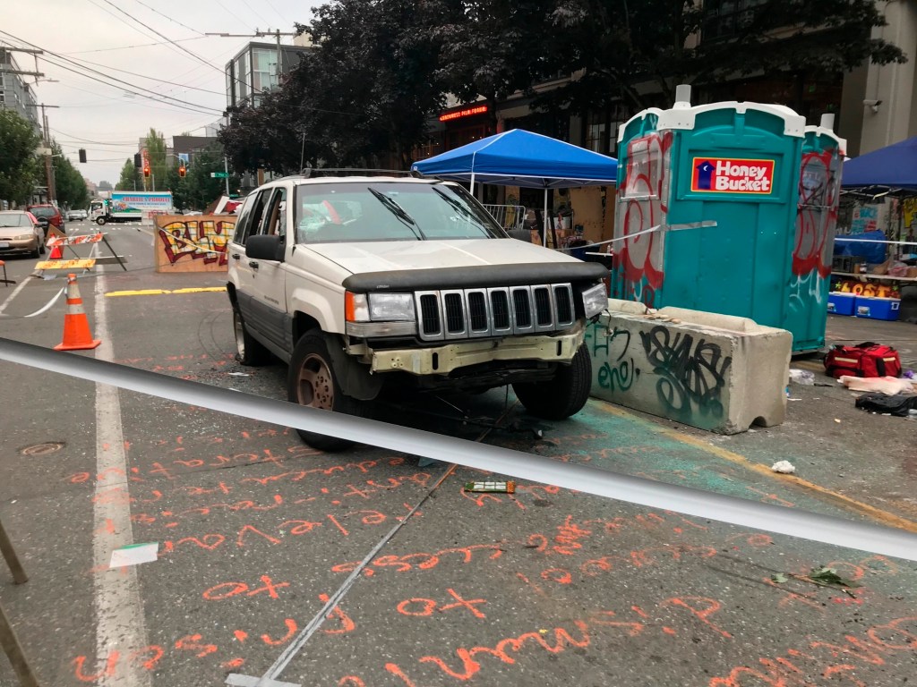 A car sits in the Capitol Hill Organized Protest zone following a shooting in Seattle early Monday, June 29, 2020. At least one man was killed and another was wounded early Monday morning when they were shot in the protest area known as CHOP, after driving the vehicle into the area. (AP Photo/Aron Ranen)