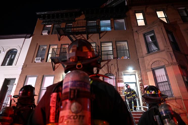 A firefighter observes a building in Brooklyn.