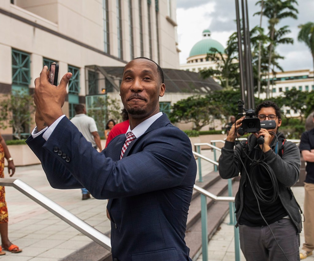 Travis Rudolph mimes catching a football while standing on the steps of the Palm Beach County Courthouse after a jury acquitted him of all charges in a fatal shooting in 2021 on June 7, 2023, in West Palm Beach, Fla. 