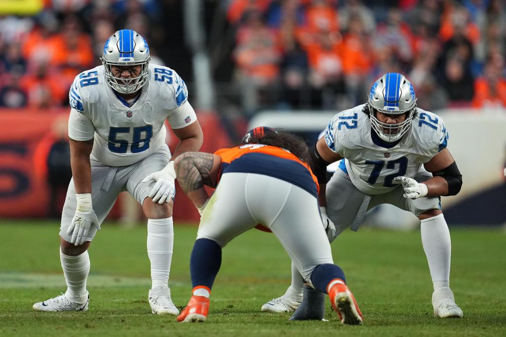 Penei Sewell #58 of the Detroit Lions and guard Halapoulivaati Vaitai (72) get set against the Denver Broncos during an NFL game at Empower Field At Mile High on December 12, 2021 in Denver, Colorado. 