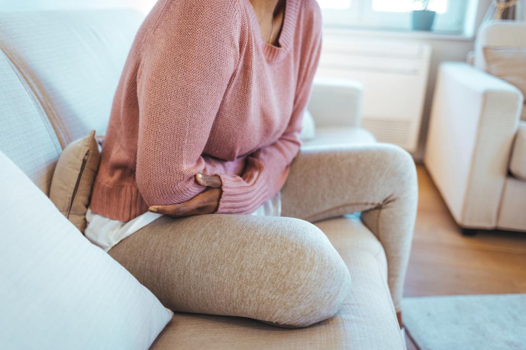 Cropped shot of an attractive young woman lying down on her bed and suffering from period pains at home