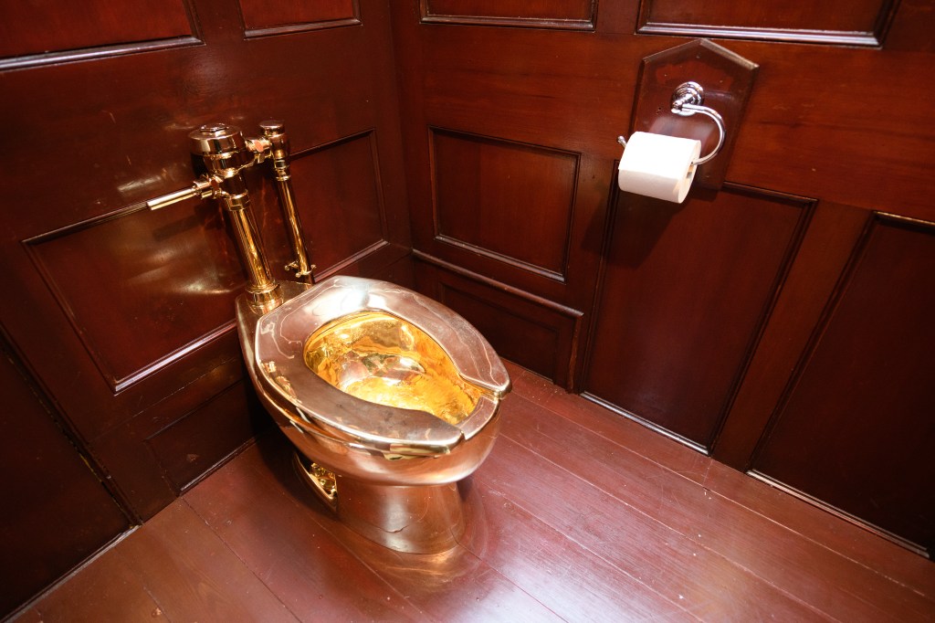 WOODSTOCK, ENGLAND - SEPTEMBER 12: "America", a fully-working solid gold toilet, created by artist Maurizio Cattelan, is seen at Blenheim Palace on September 12, 2019 in Woodstock, England.  The Italian artist is known as the prankster of the art world.  His most notable piece being "America" a solid gold usable toilet which had art lovers queuing to use when it was shown at the Guggenheim Museum in New York. (Photo by Leon Neal/Getty Images)