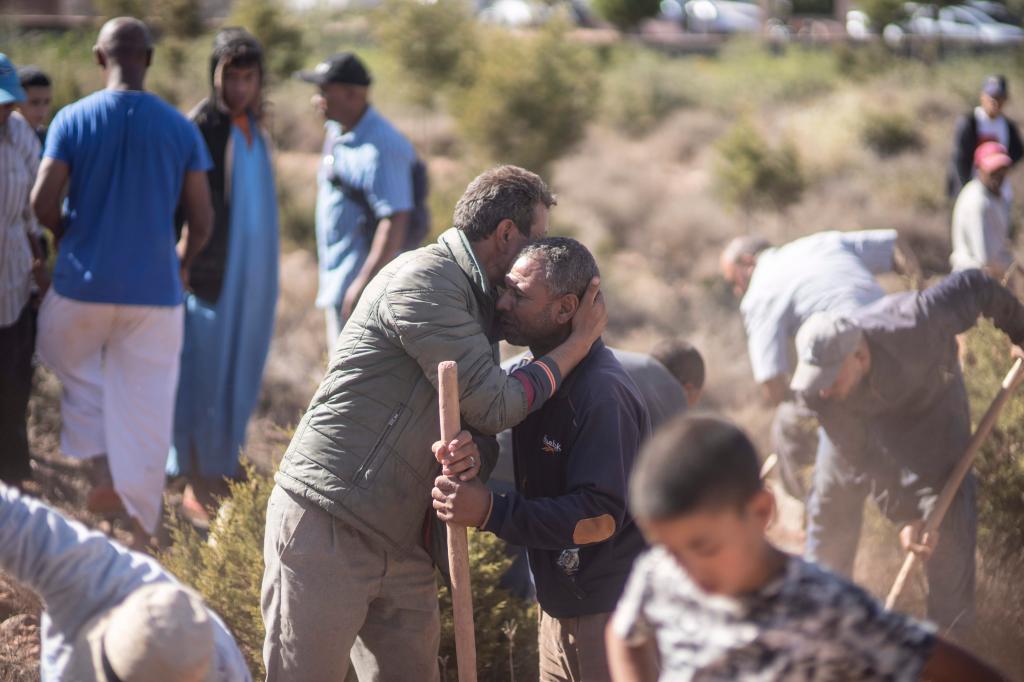 People comforting each other while digging gaves for victims in in Ouargane village, near Marrakech.