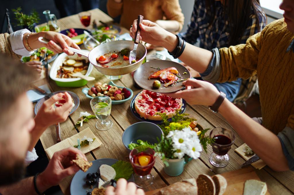 Photo of food and people eating around a table. 