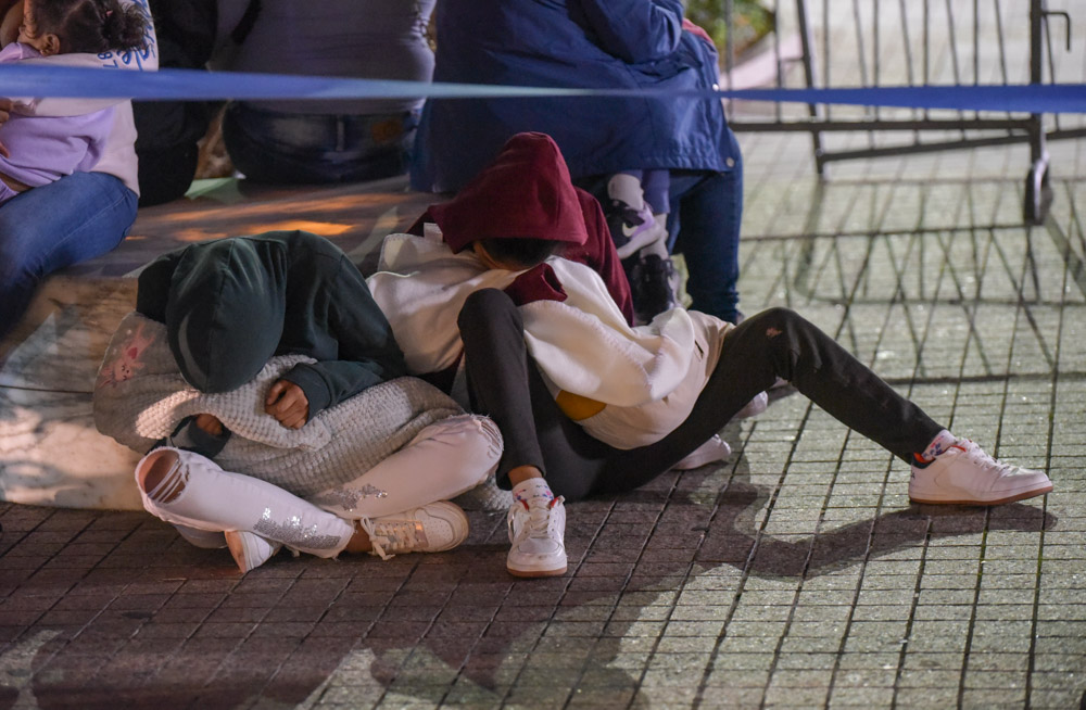 Migrants sleep in the line outside Federal Plaza on Friday morning.