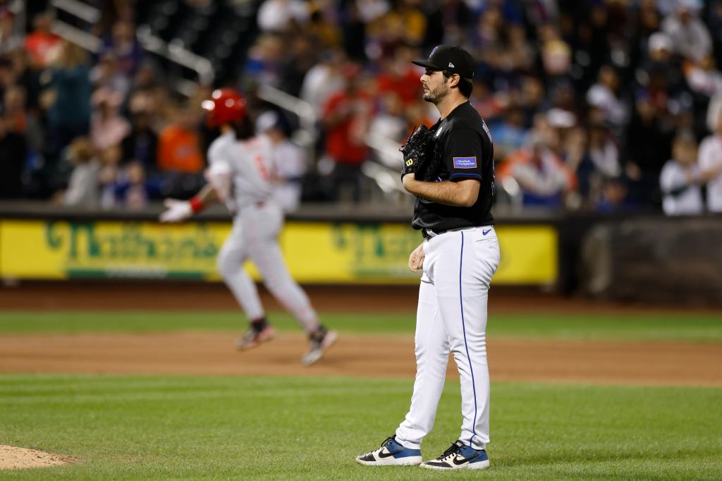 Mets relief pitcher Grant Hartwig reacts on the mound after giving up a two-run homer in the 7th inning against the Cincinnati Reds.