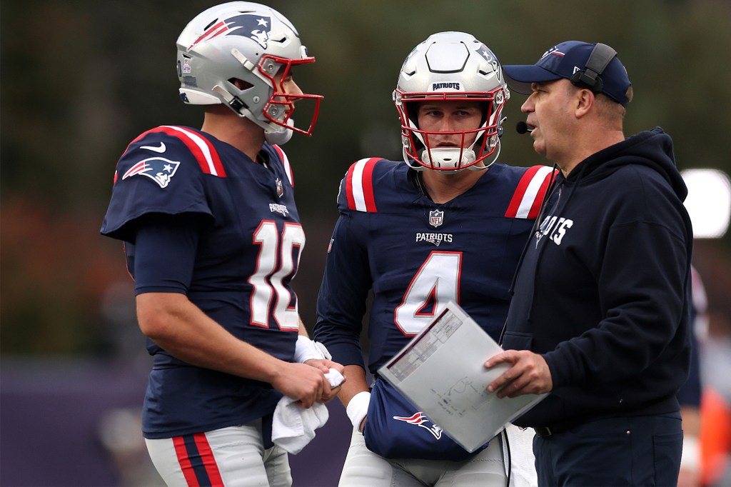 Quarterbacks Mac Jones and Bailey Zappe speak with offensive coordinator Bill O'Brien in October 2023.