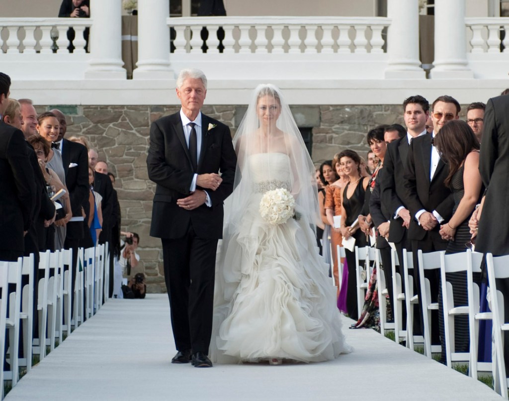 Bill Clinton walks Chelsea down the aisle as Ghislaine Maxwell looks on.