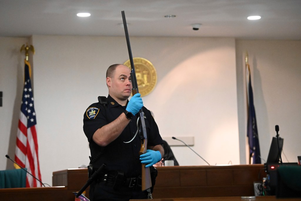 A police officer holding a shotgun during summations in Kevin Monahan's murder trial at Washington County Courthouse.