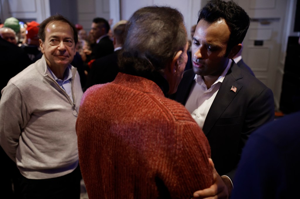 Former Republican presidential candidate Vivek Ramaswamy, John Paulson, and Steve Wynn at a primary victory rally with Donald Trump in a room.