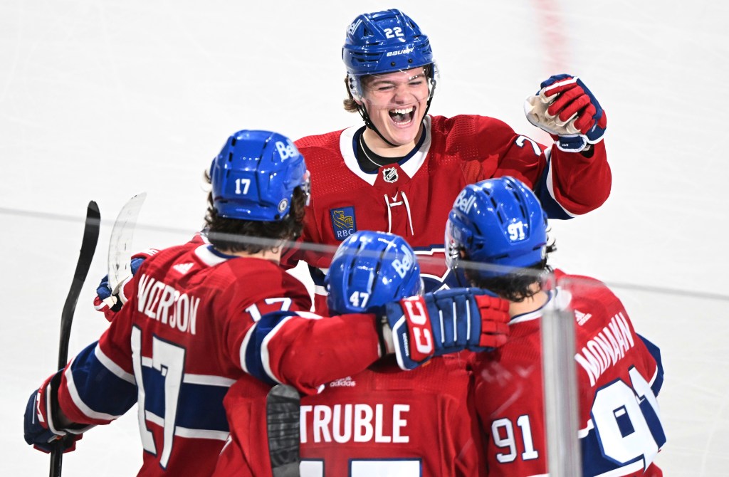 Montreal Canadiens' Sean Monahan (91) celebrates with Cole Caufield (22), Jayden Struble (47) and Josh Anderson (17) after scoring against the New York Islanders during the third period of an NHL hockey game Thursday, Jan. 25, 2024