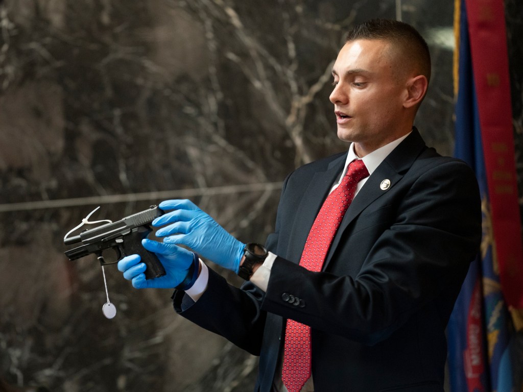 ATF Special Agent Brett Brandon holds up and identifies the SIG Sauer murder weapon used by Ethan Crumbley in the Oxford High School shootings