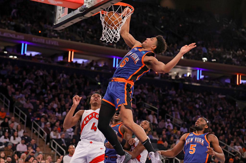 Quentin Grimes #6 of the New York Knicks slams the ball over Scottie Barnes #4 of the Toronto Raptors during the second half. The New York Knicks defeated the Toronto Raptors 126-100.