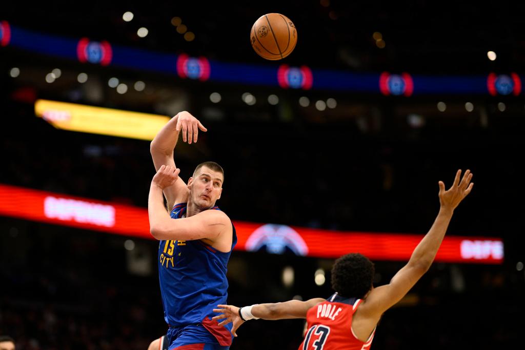 Denver Nuggets center Nikola Jokic (15) passes the ball against Washington Wizards guard Jordan Poole (13) during the second half of an NBA basketball game, Sunday, Jan. 21, 2024, in Washington. 