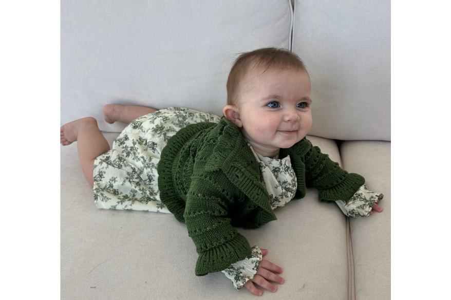 baby wearing green dress and cardigan from Babybala