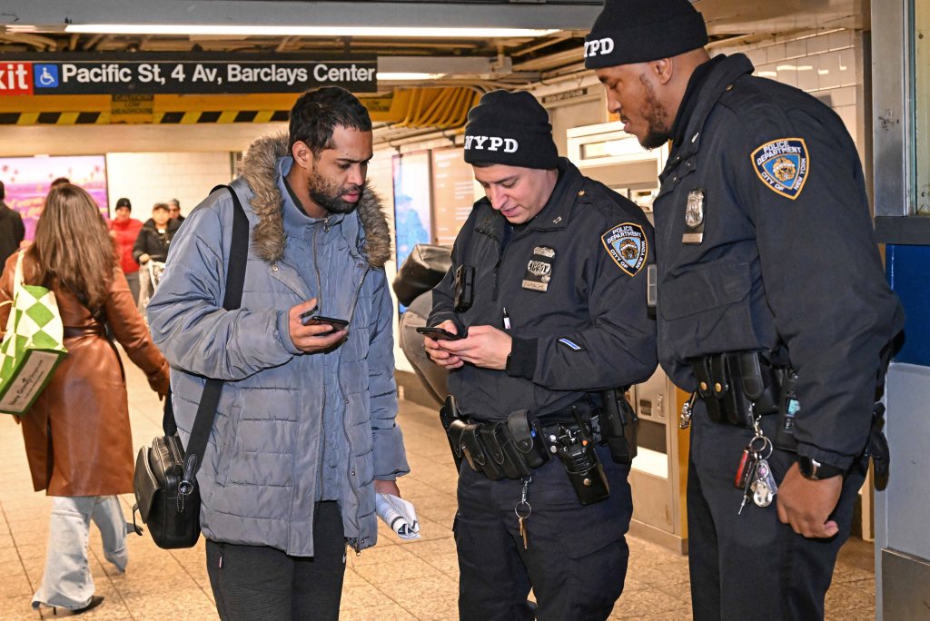 NYPD officers at Atlantic Avenue/Barclays Center subway station assisting customers with directions and using turnstiles and pay stations.