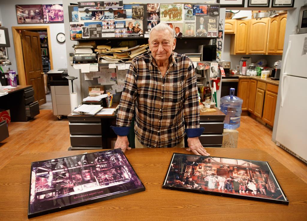 Stephen DeMaria poses with some of the many old "Saturday Night Live" photos that hang around his office. 