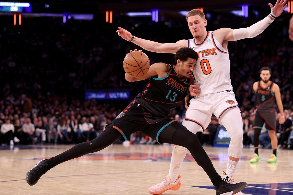 Jordan Poole #13 of the Washington Wizards heads for the net as Donte DiVincenzo #0 of the New York Knicks defends at Madison Square Garden on January 18, 2024 in New York City. 