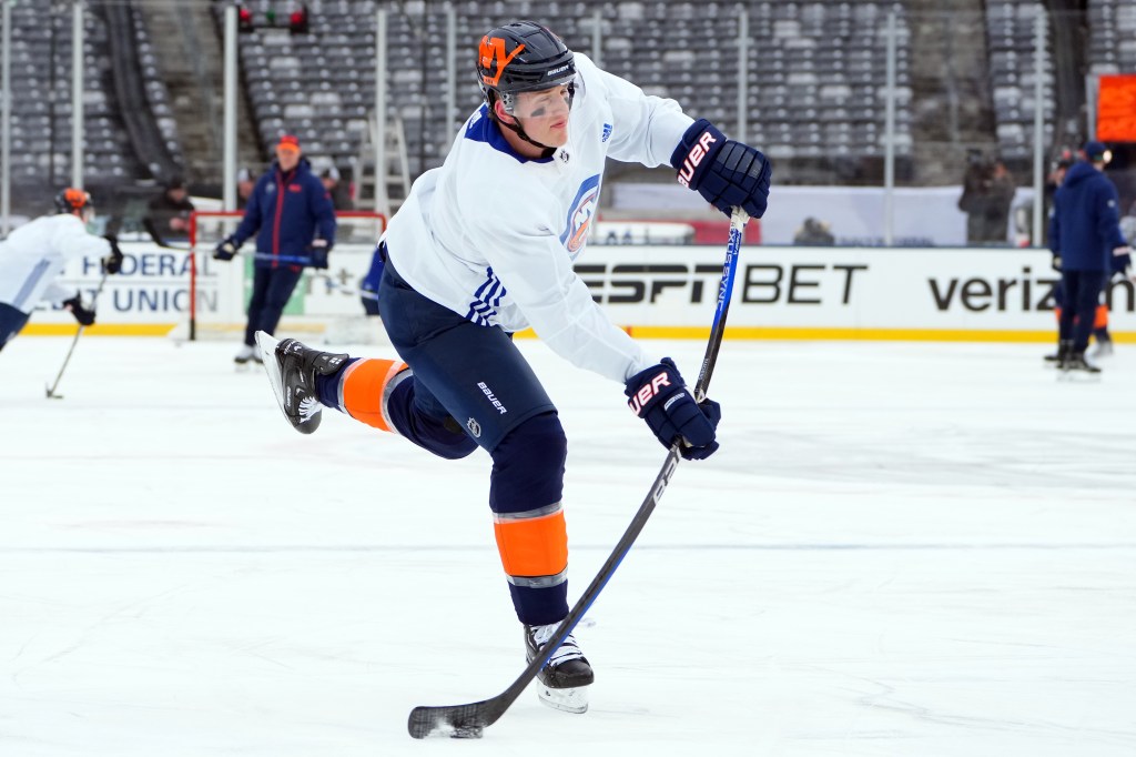 Hudson Fasching #20 of New York Islanders attempting a shot during 2024 Navy Federal Credit Union Stadium Series on ice.