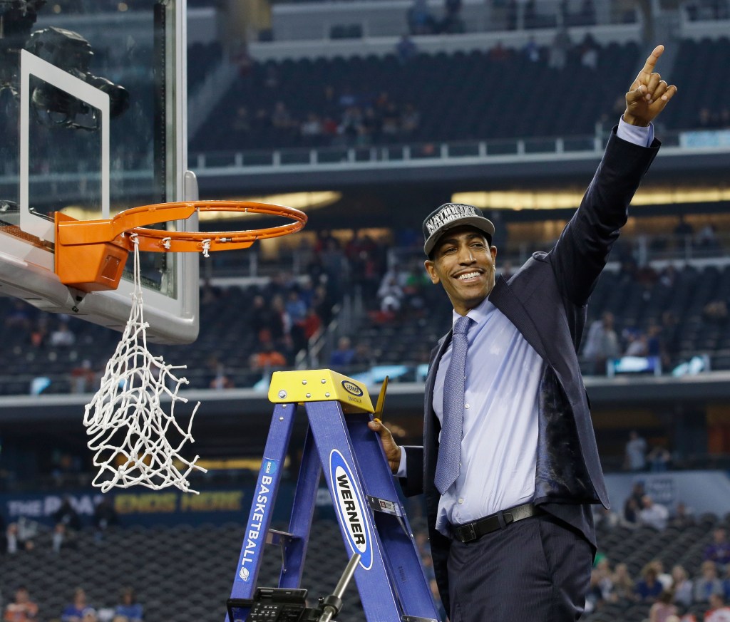 Kevin Ollie cuts down the net after UConn wins the national championship on April 7, 2014.