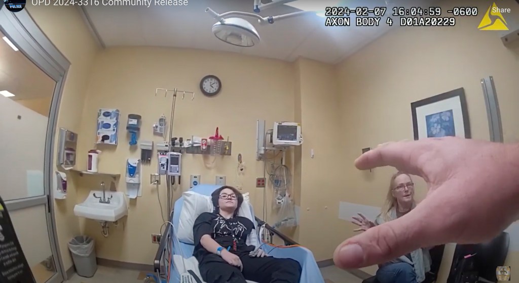 Nonbinary student Nex Benedict and mother speaking to a police officer in a hospital room after Nex was knocked down during a school fight.