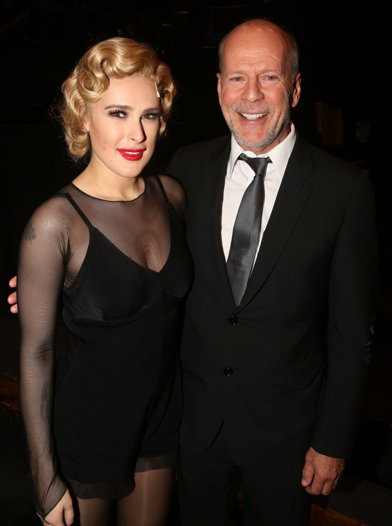 Rumer Willis and father Bruce Willis smiling. 