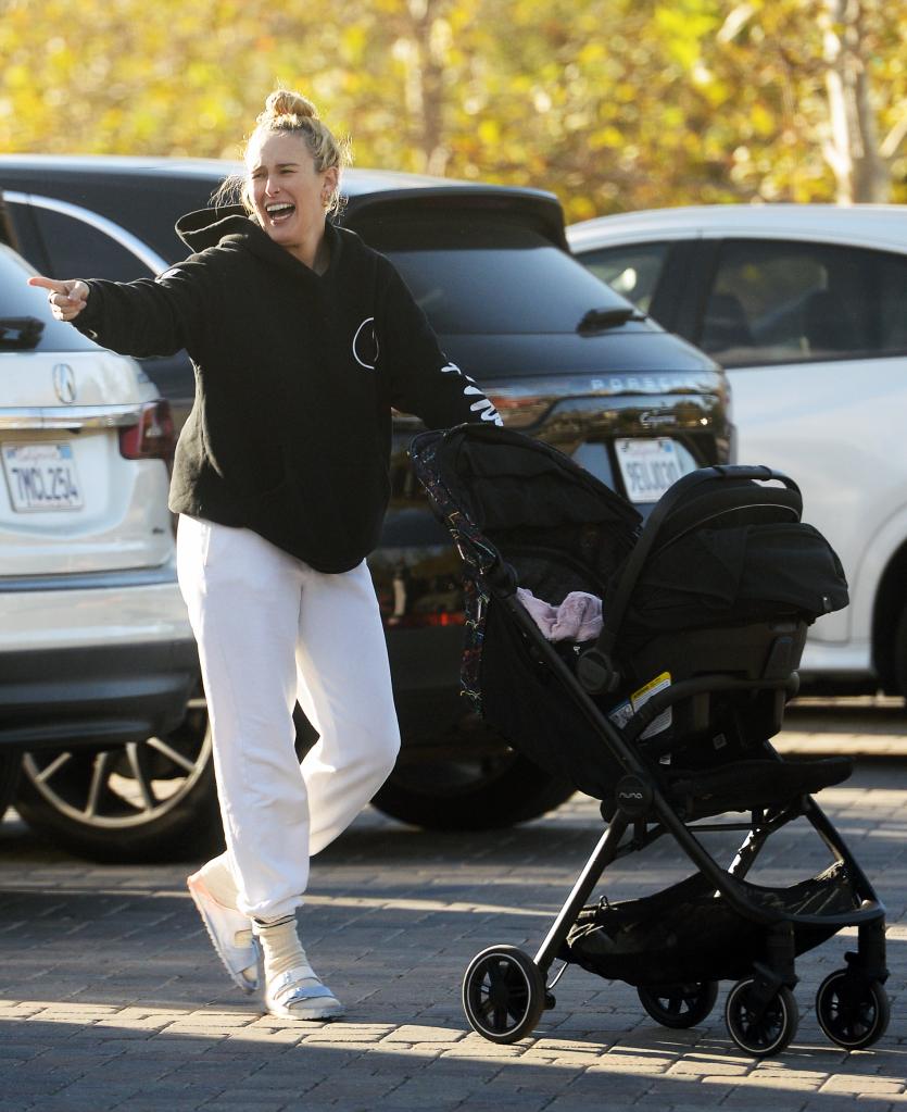 Rumer Wills smiling and pushing a stroller. 