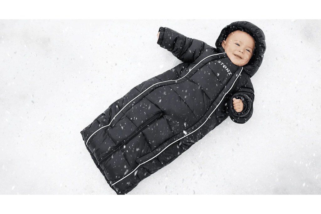 a baby lying in a black sleeping bag from stonz