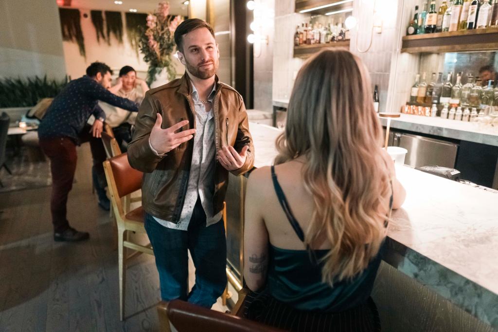 Drayton speaking to woman at a bar in midtown. 