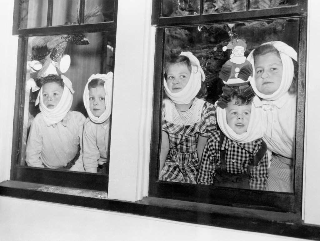 Youngsters with mumps watch through the window as other kids play in the snow.