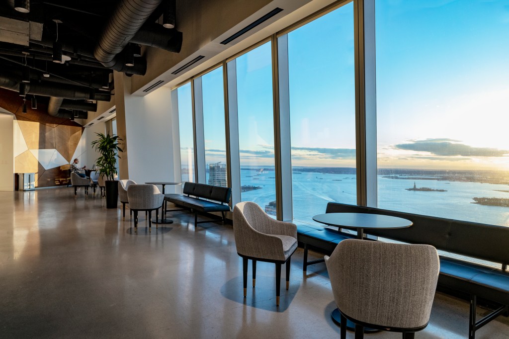 An upper floor lounge with views of the East River at One World Trade Center. 