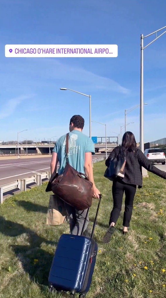 People walking with suitcases outside the airport.