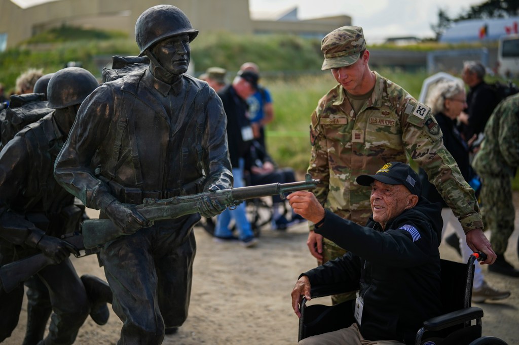 American World War II veteran Anthony Pagano, 97, touches a sculpture prior a ceremony at Utah Beach near Sainte-Marie-du-Mont, Normandy, France, Wednesday, June 5, 2024.