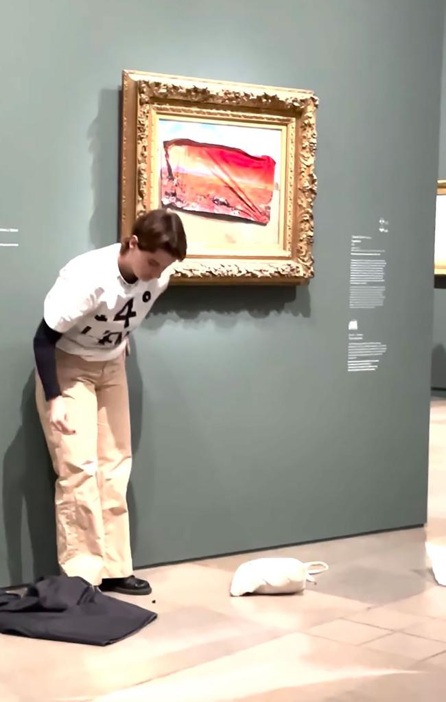 An environmental activist placing a protest sticker depicting a 'Poppy Field' painting ravaged by flames and drought onto a Monet painting at Paris Orsay Museum.