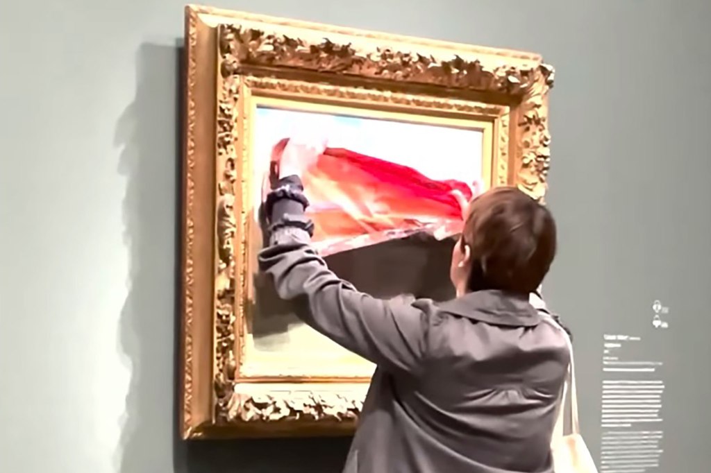 An environmental activist placing a protest sign on a Monet painting in Paris' Orsay Museum, with the sign depicting the 'Poppy Fields painting ravaged by flames and drought.