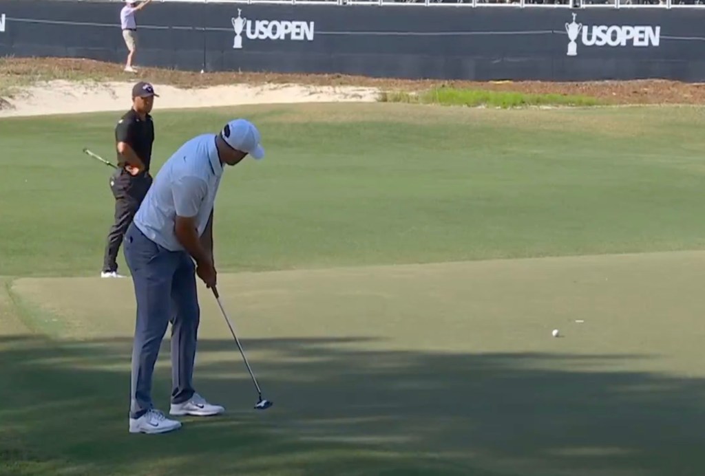 Scottie Scheffler, world's top-ranked golfer, flipping his putter into the air in frustration at the U.S. Open on Pinehurst No. 2 green