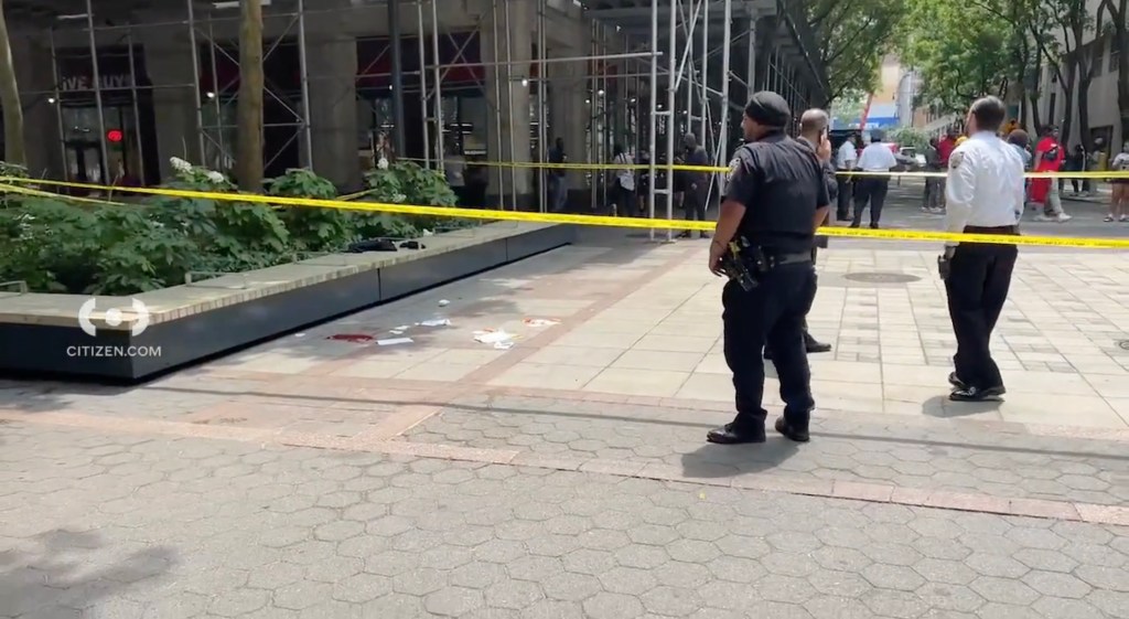 Police officers in a courtyard in brooklyn with yellow crime scene tape