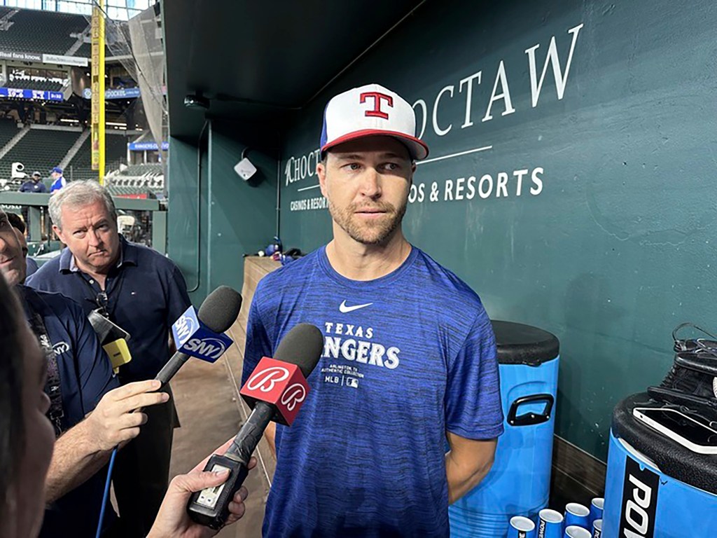 Jacob deGrom speaks to reporters in the dugout before a baseball game against the New York Mets in Arlington, Texas.