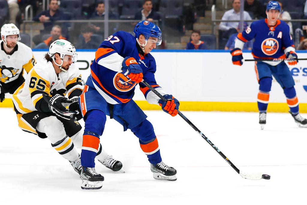 New York Islanders center Ruslan Iskhakov (37) shoots the puck against Pittsburgh Penguins defenseman Erik Karlsson (65) during the third period of an NHL hockey game, Wednesday, April 17, 2024 in Elmont, N.Y. 