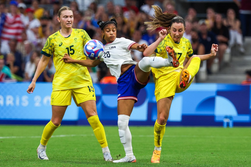 US forward #20 Croix Bethune fights for the ball with Australia's defender #15 Clare Hunt and midfielder #17 Clare Wheeler.