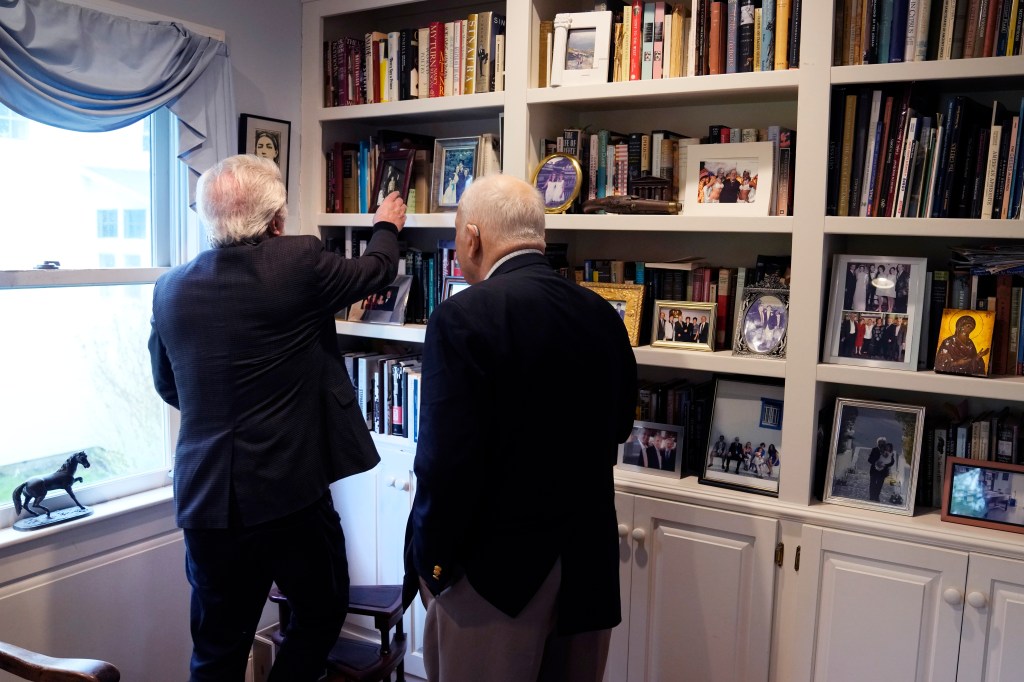 Authors Nick Gage and Nicholas Basbanes selecting a book from a library in Grafton, Mass, amid copyright controversy with OpenAI and Microsoft