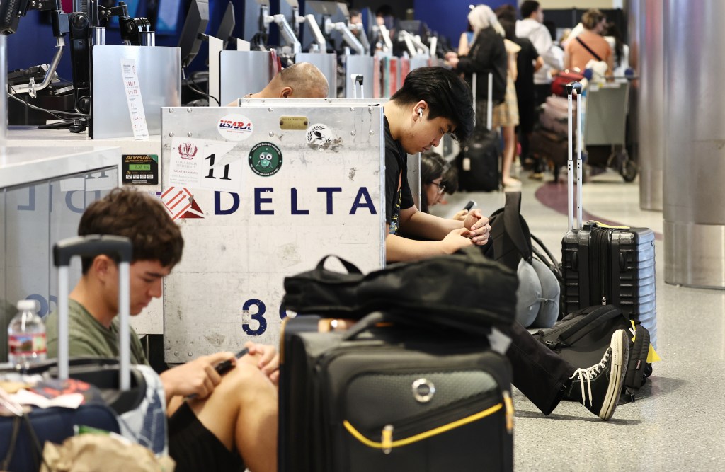 Passengers wait with baggage in airport.