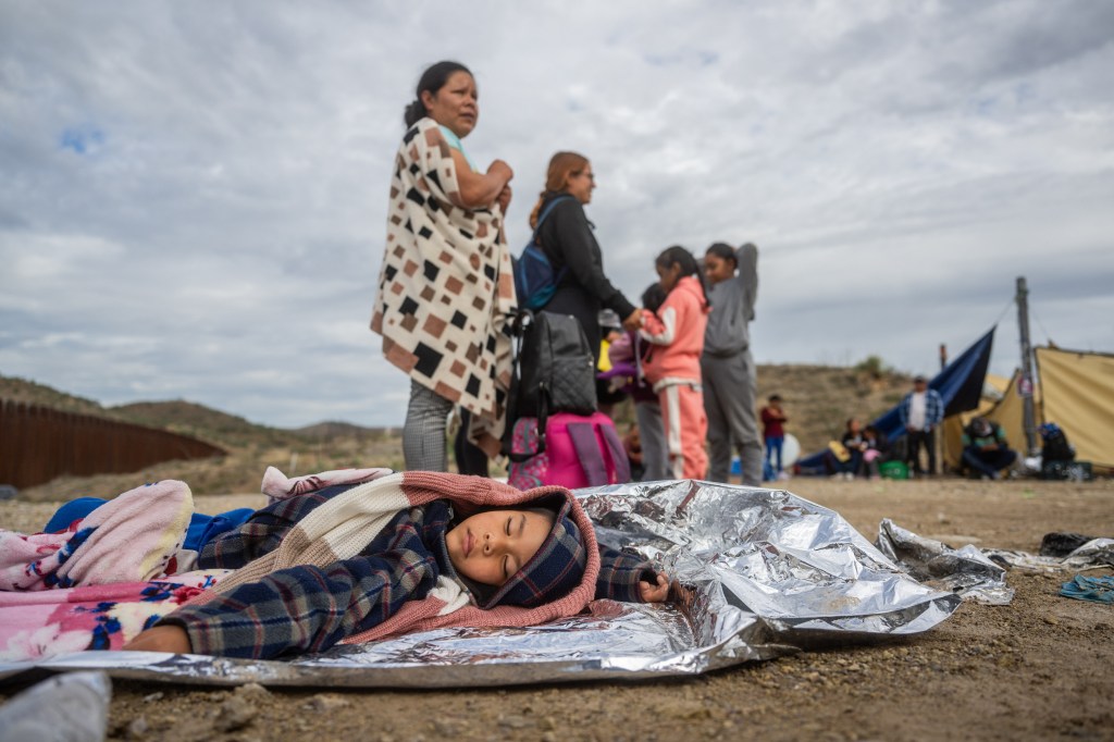 Mexican migrant Mariano Marquez, 5, sleeps on the ground while waiting for his family to be apprehended by U.S. Customs and Border protection officers after crossing over into the U.S. on June 25, 2024 in Ruby, Arizona. 