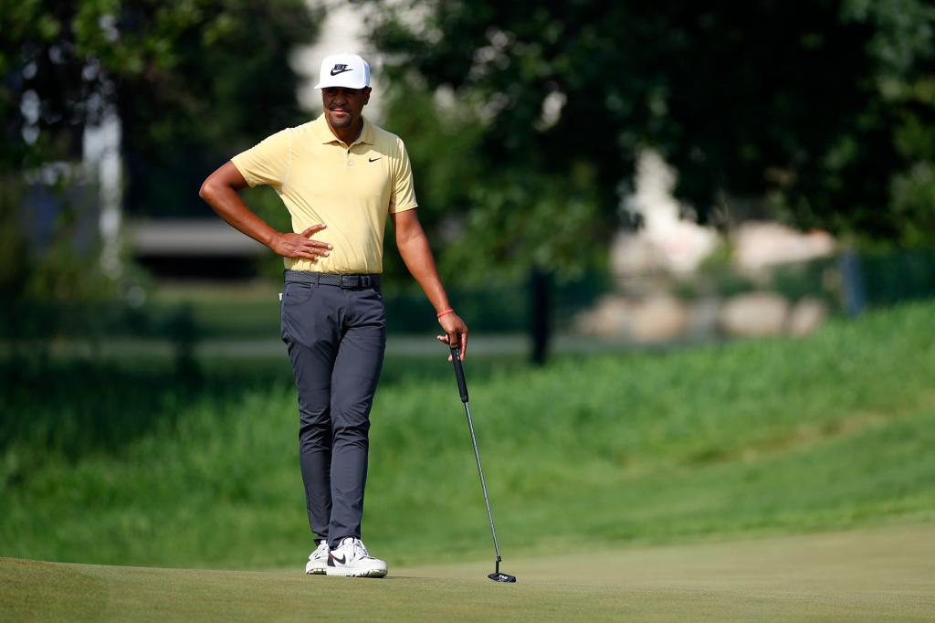 Tony Finau, a professional golfer, scanning the course while holding a golf club during the first round of the 3M Open in Blaine, Minnesota