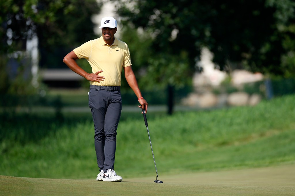 Tony Finau, a professional golfer, scanning the course while holding a golf club during the first round of the 3M Open in Blaine, Minnesota