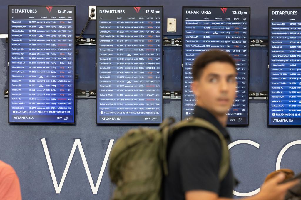 Delta Airlines flight status signs in airport show lots of delayed flights.