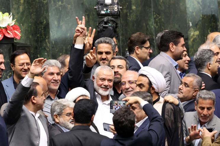 Hamas political leader Ismail Haniyeh (C) flashes victory sign as surrounded by Iranian lawmakers at the Iranian parliament in Tehran, Iran, 30 July 2024.