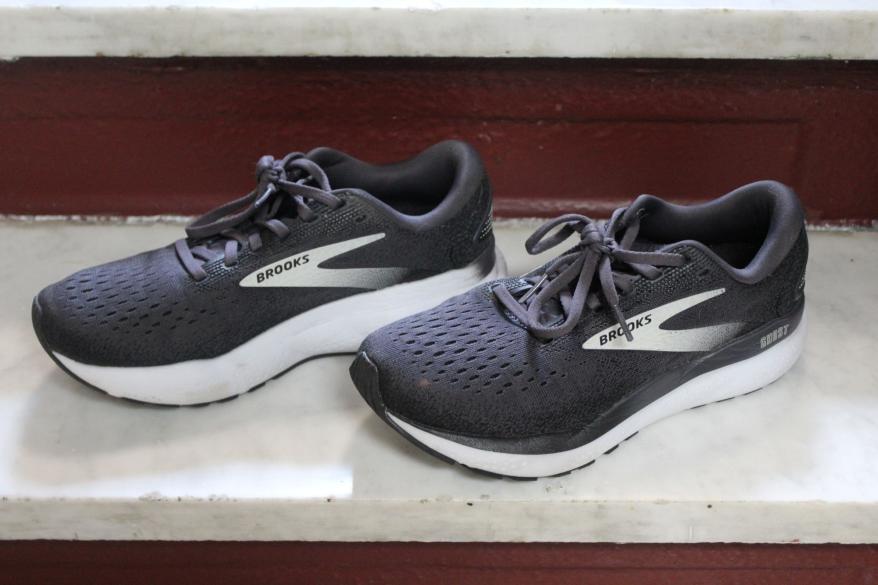 A pair of black sneakers on a marble staircase.