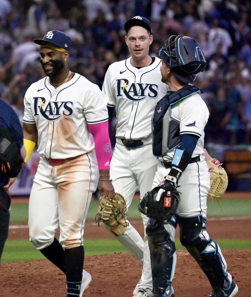 Tampa Bay Rays, from left, Yandy Diaz, Pete Fairbanks and Ben Rortvedt walk off the field after a 5-4 win over the New York Yankees following a baseball game Thursday, July 11, 2024, in St. Petersburg, Fla. 