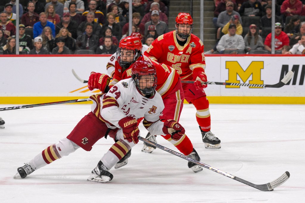 Boston College Eagles forward Gabe Perreault (34) skates the puck around Denver Pioneers defenseman Sean Behrens (2) during the first period of the championship game of the 2024 Frozen Four college ice hockey tournament at Xcel Energy Center. 